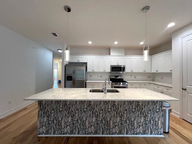 kitchen featuring wood-type flooring, white cabinetry, sink, and appliances with stainless steel finishes