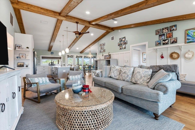 living room with sink, ceiling fan, vaulted ceiling with beams, and light hardwood / wood-style flooring