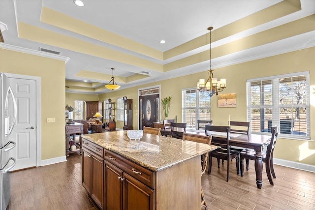 kitchen featuring a center island, decorative light fixtures, and a tray ceiling