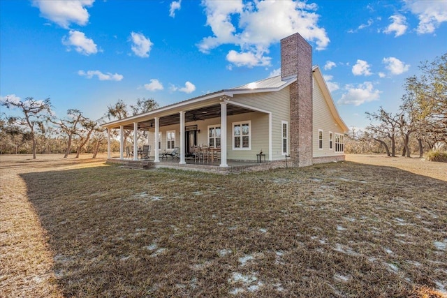 rear view of house with a yard, a patio, and ceiling fan