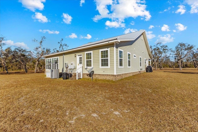 exterior space with central air condition unit and a lawn