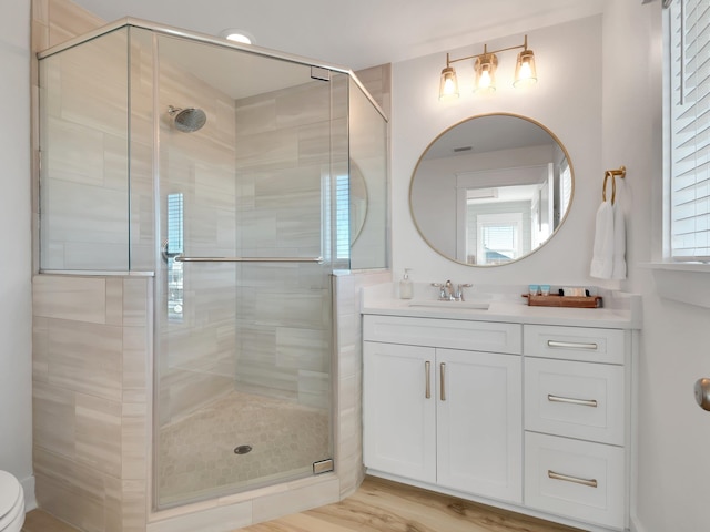 bathroom with vanity, an enclosed shower, and hardwood / wood-style flooring