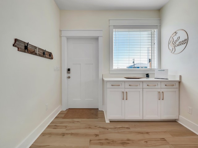 kitchen featuring light wood-type flooring and white cabinets