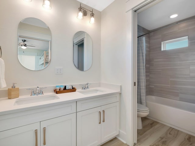 full bathroom featuring hardwood / wood-style flooring, ceiling fan, shower / tub combo with curtain, vanity, and toilet