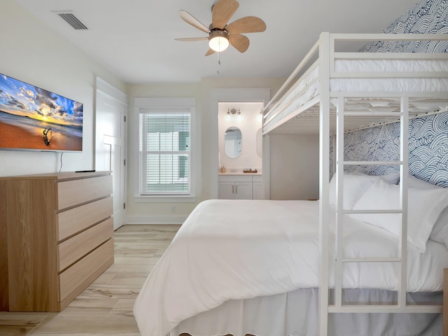 bedroom with ceiling fan, ensuite bath, and light hardwood / wood-style flooring