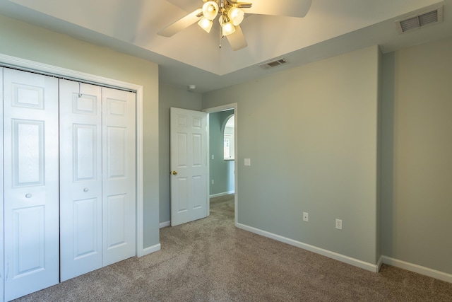 unfurnished bedroom with carpet floors, a closet, and ceiling fan