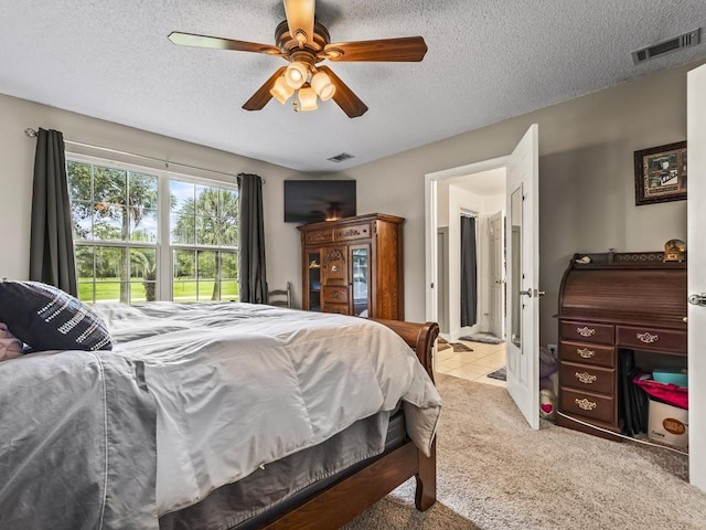 carpeted bedroom with ceiling fan and a textured ceiling