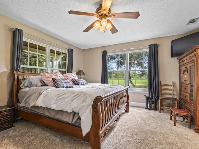 bedroom featuring ceiling fan, carpet floors, and a textured ceiling