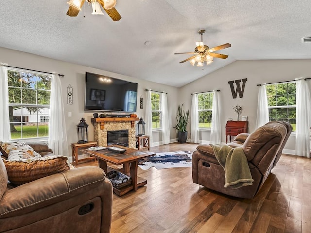 living room with hardwood / wood-style flooring, a fireplace, vaulted ceiling, and a textured ceiling