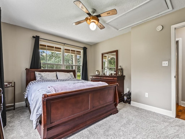 carpeted bedroom featuring ceiling fan and a textured ceiling