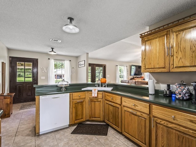 kitchen featuring a healthy amount of sunlight, dishwasher, sink, and kitchen peninsula