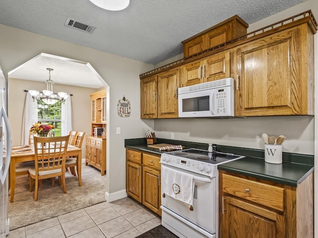 kitchen featuring light tile patterned floors, white appliances, a chandelier, and a textured ceiling