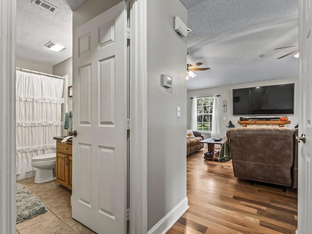 hallway featuring light hardwood / wood-style floors and a textured ceiling