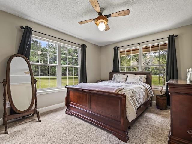 carpeted bedroom with ceiling fan and a textured ceiling