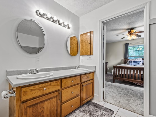 bathroom featuring ceiling fan, tile patterned floors, vanity, and a textured ceiling