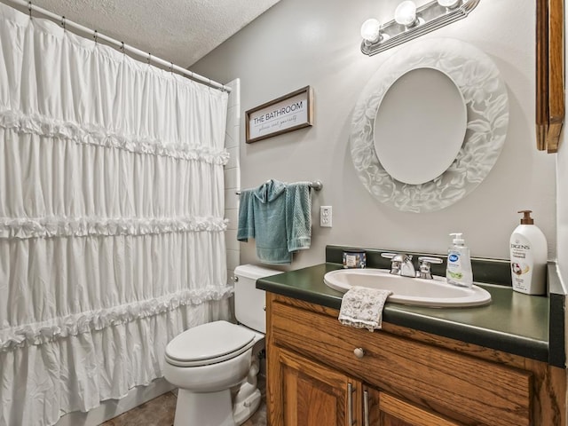 bathroom with vanity, toilet, curtained shower, and a textured ceiling