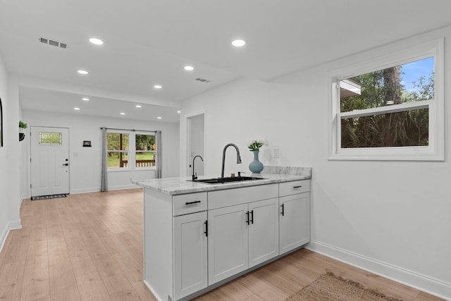 715 Caliark St, Tallahassee, FL 32304 - kitchen with a peninsula, light wood finished floors, recessed lighting, light stone countertops, and white cabinets