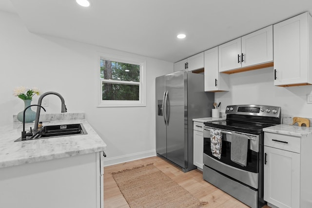 715 Caliark St, Tallahassee, FL 32304 - kitchen featuring appliances with stainless steel finishes, white cabinets, light wood-style floors, recessed lighting, and light stone counters