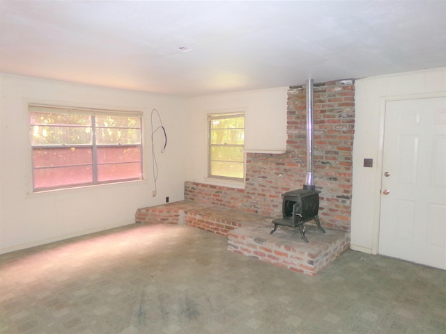 906 NE 1st St, Havana, FL 32333 - unfurnished living room featuring a wood stove and carpet floors