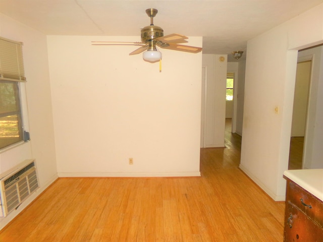 906 NE 1st St, Havana, FL 32333 - unfurnished living room with light wood-type flooring, a ceiling fan, a wall mounted AC, and baseboards