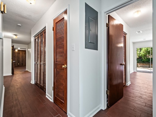 hallway featuring dark hardwood / wood-style floors, electric panel, and a textured ceiling