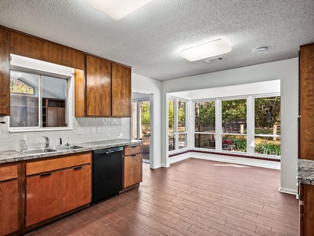 kitchen featuring sink, backsplash, black dishwasher, a textured ceiling, and dark hardwood / wood-style flooring