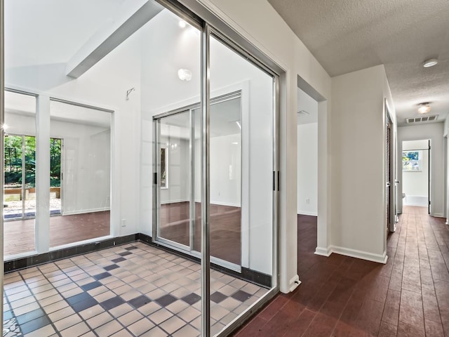 interior space featuring dark hardwood / wood-style flooring, lofted ceiling, and a textured ceiling