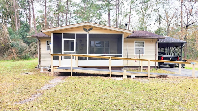 view of front of home with a front lawn, a carport, and a sunroom