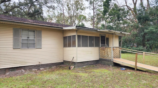 view of property exterior with a sunroom and a yard