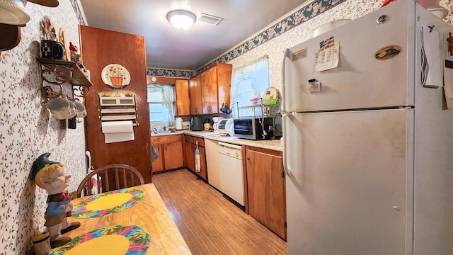 kitchen with white appliances and light wood-type flooring