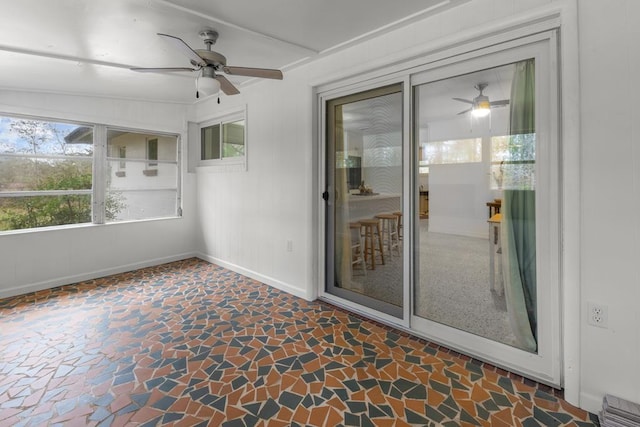 unfurnished sunroom with ceiling fan