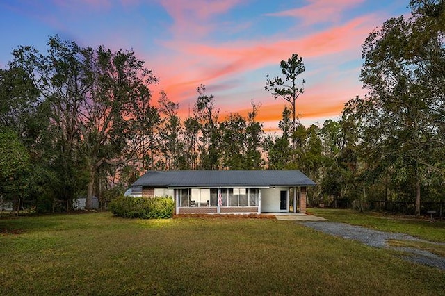 single story home featuring driveway and a front lawn