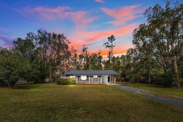 ranch-style home with a yard and a porch