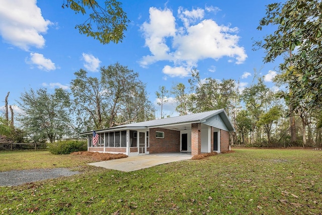 back of property featuring a patio area, a sunroom, and a lawn