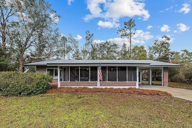 view of front of house with a sunroom, a carport, and a front yard