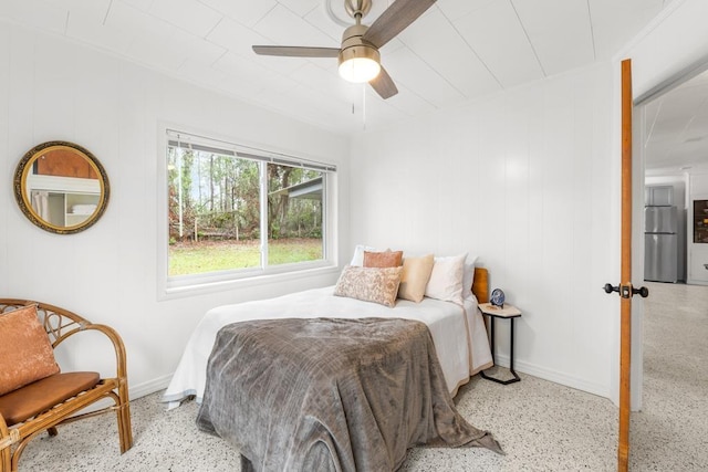 bedroom with ceiling fan and stainless steel refrigerator