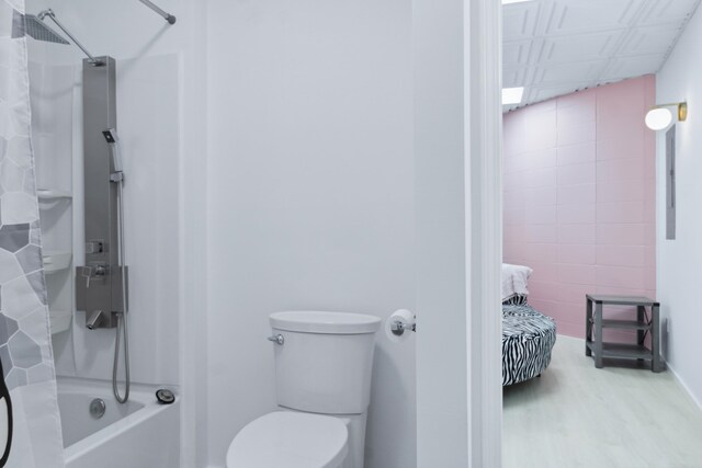 bathroom with shower / tub combo with curtain, toilet, and wood-type flooring