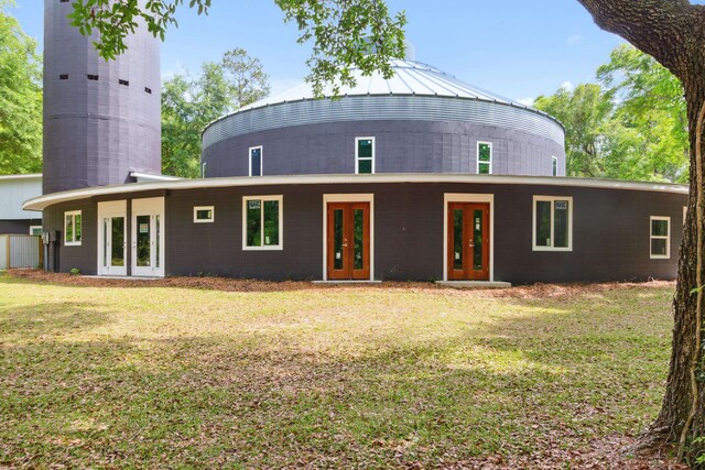 rear view of house featuring a lawn and french doors