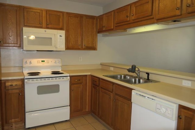 kitchen featuring white appliances, sink, and light tile patterned floors