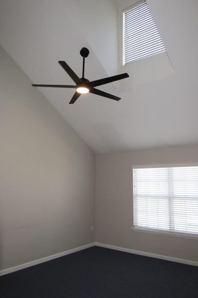 carpeted spare room featuring lofted ceiling and ceiling fan