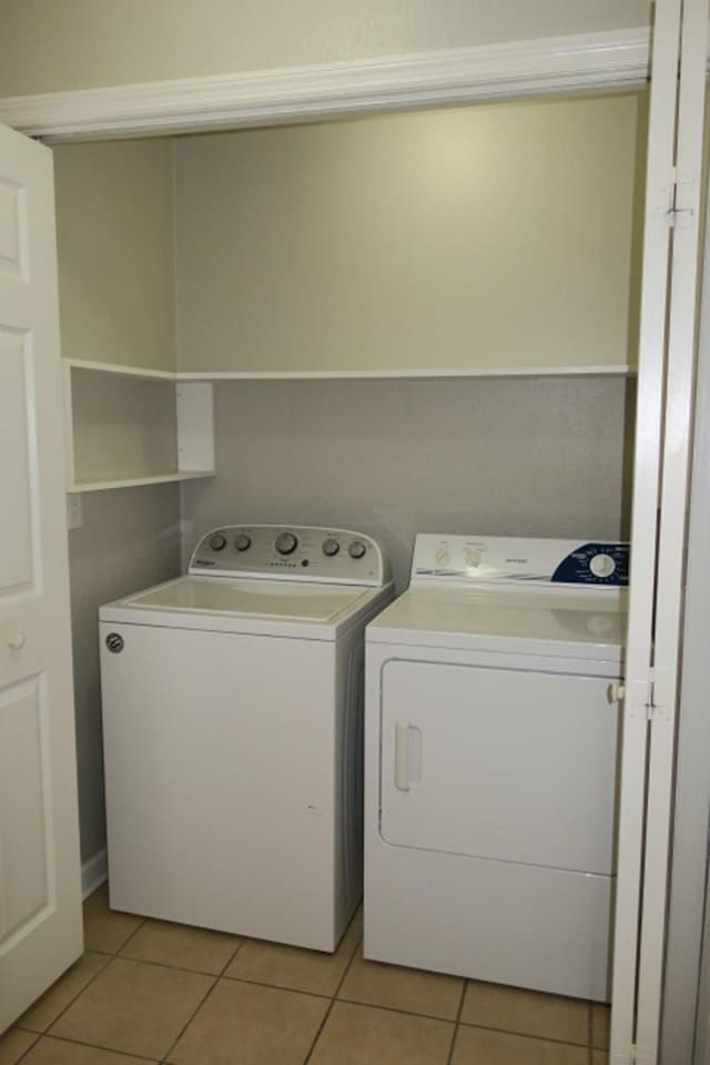 washroom with washer and clothes dryer and light tile patterned flooring