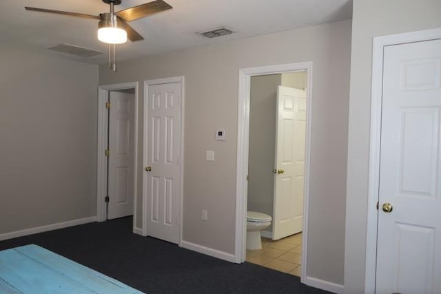 unfurnished bedroom with light tile patterned flooring, ceiling fan, and connected bathroom