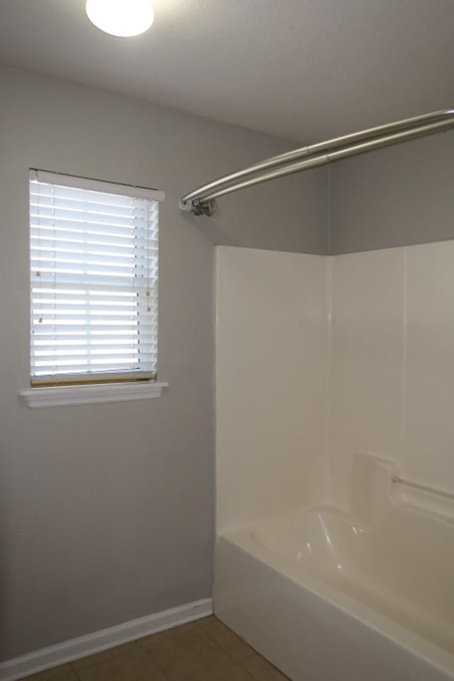 bathroom featuring tile patterned flooring and bathing tub / shower combination