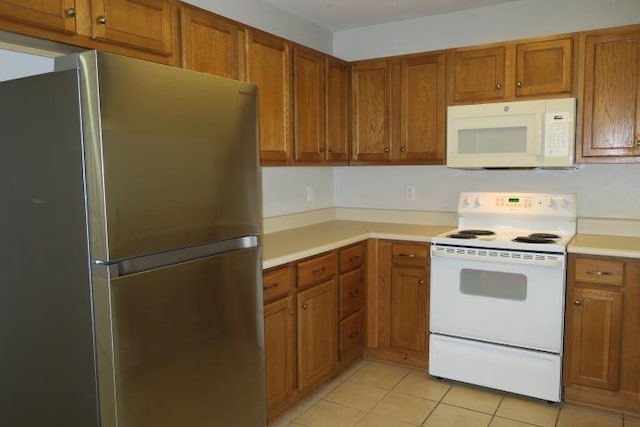 kitchen with white appliances and light tile patterned floors