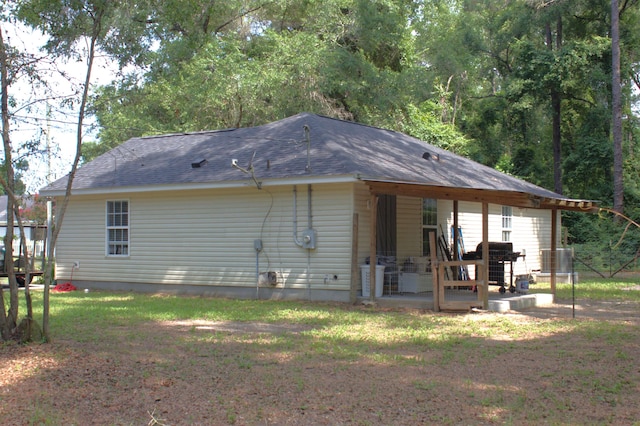 29 Chippewa Rd, Crawfordville, FL 32327 - rear view of house with a patio, a shingled roof, and a lawn