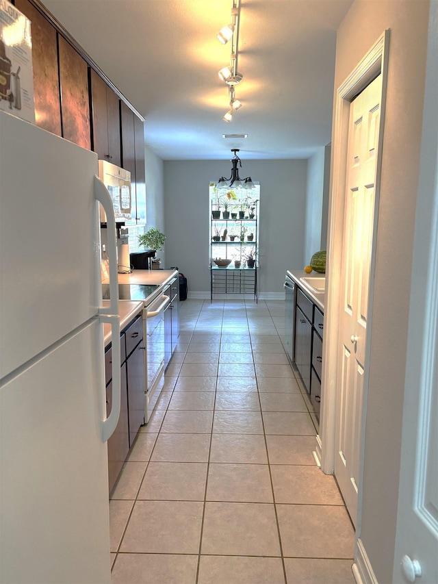 29 Chippewa Rd, Crawfordville, FL 32327 - kitchen with white appliances, light tile patterned floors, light countertops, and rail lighting
