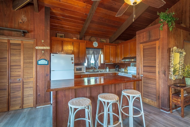 kitchen featuring lofted ceiling with beams, dark hardwood / wood-style flooring, sink, and white appliances