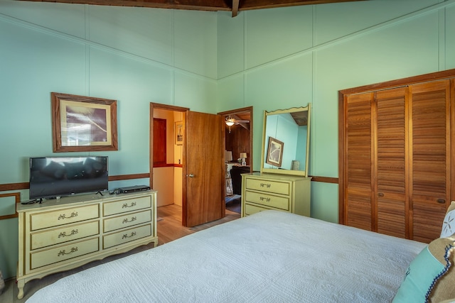 bedroom featuring high vaulted ceiling, light hardwood / wood-style flooring, and beamed ceiling