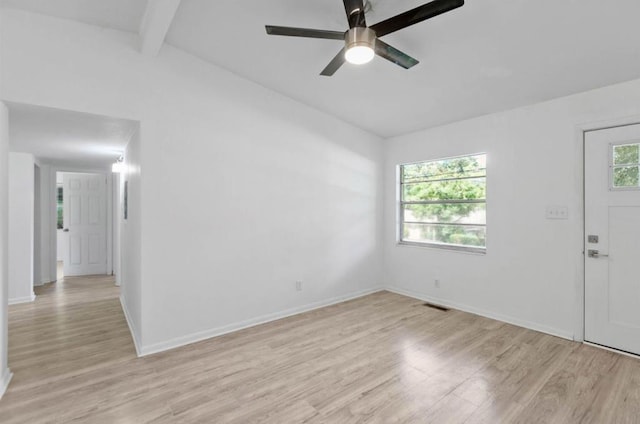 empty room featuring ceiling fan, vaulted ceiling with beams, and light wood-type flooring