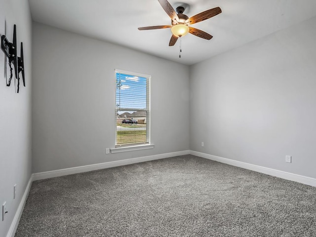 carpeted empty room featuring ceiling fan and baseboards